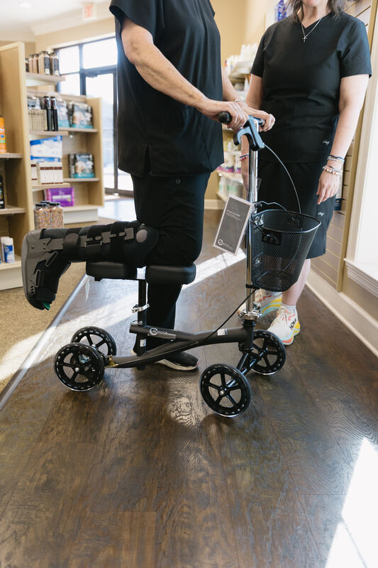 A patient being fitted for a knee scooter at Mitchell's Pharmacy